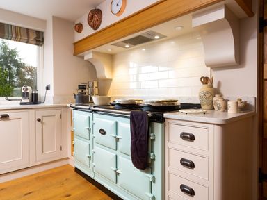 A kitchen with a light blue stove white cabinets and countertop at High Cunsey Farm in Far Sawrey