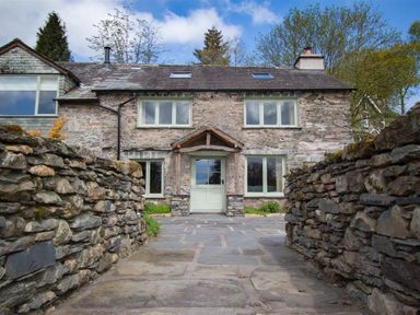 Stone cottage with a path and stone walls leading to the front door at High Cunsey Farm Far Sawrey