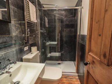 A bathroom with a sink toilet and shower with glass door at Fairy Glen in Grasmere near Ambleside