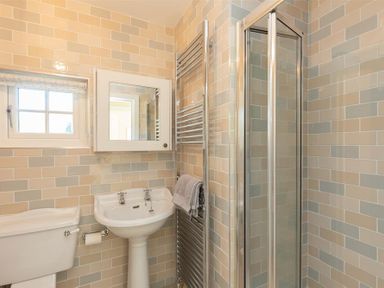 A bathroom with a toilet sink shower and towel rack at Crozier Cottage in Grasmere
