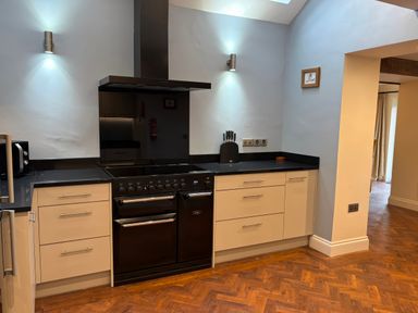 A kitchen with cabinets and an oven at Dancing Beck Cottage in Millbeck