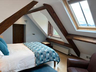 A bedroom with a bed and window at Dancing Beck Cottage in Millbeck