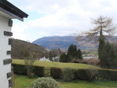 A garden with bushes and trees overlooking a valley and mountains at Bandol in Braithwaite