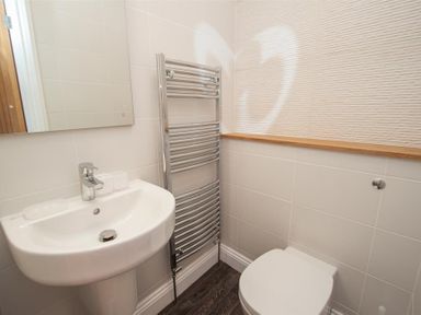 A bathroom with a sink a mirror a towel radiator and a toilet at Gable End in Braithwaite