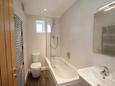 A bathroom with a bathtub shower toilet sink mirror and towel rack at Gable End in Braithwaite