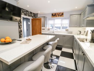 A kitchen with a countertop island and gray cabinets at Meadow View in Tyn-y-Gongl near Benllech