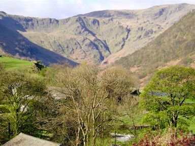 A view of a valley with trees and hills in the background at Thomas Cottage in Hartsop