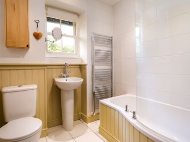 A bathroom with a toilet sink bathtub and heated towel rail at Greystones in Bowness