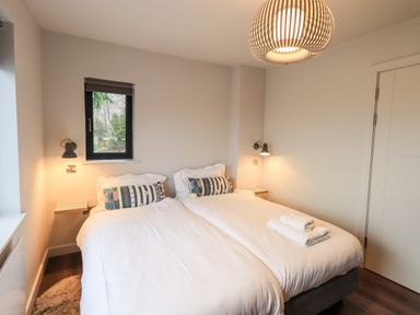 A bedroom with two single beds pushed together with white bedding and patterned pillows at Gillside in Millbeck
