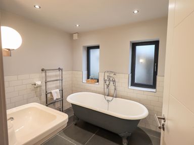 A bathroom with a freestanding bathtub towel rack and sink at Gillside in Millbeck