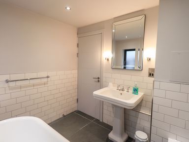 A bathroom with a pedestal sink mirror and towel rack at Gillside in Millbeck