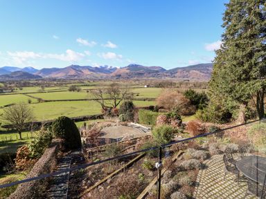 A garden with patio furniture and hedges overlooking fields and mountains at Gillside in Millbeck