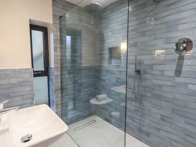 A bathroom with a walk-in shower glass partition and a white sink at Gillside in Millbeck