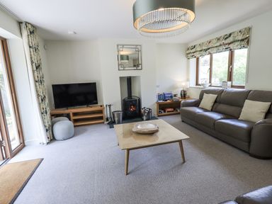A living room with a fireplace and television at No 7 Ambleside