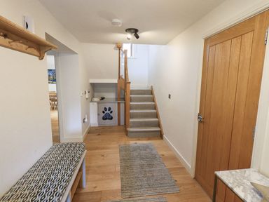 A hallway with a staircase and bench at No 7 Ambleside