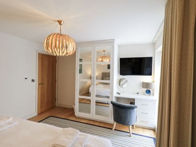 A bedroom with a wardrobe and television at No 7 in Ambleside