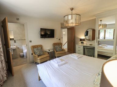 A bedroom with two armchairs and a television at No 7 Ambleside