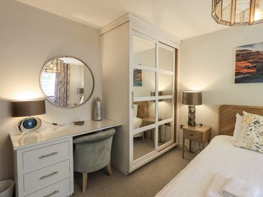 A bedroom with a bed, desk, and mirror at No 7 in Ambleside