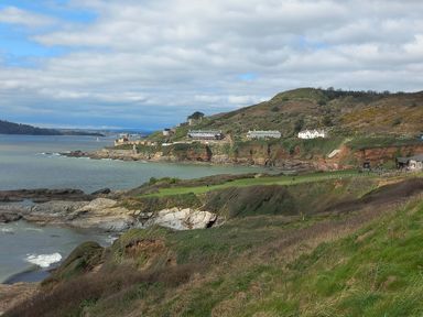 A coastal landscape with cliffs greenery and buildings near the water at SoundView in Down Thomas