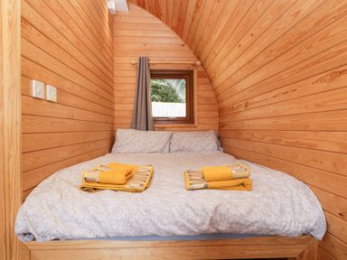 A bedroom with a double bed and yellow towels on the bed at Halmore Pod in Halmore near Berkeley