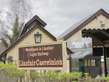 A sign for Welshpool and Llanfair light railway outside a station building at Llanfair Caereinion