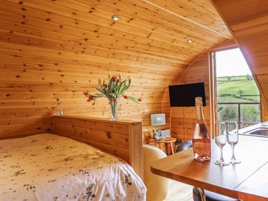 A bedroom with a bed and a table at The Rhiw in Llanfair Caereinion
