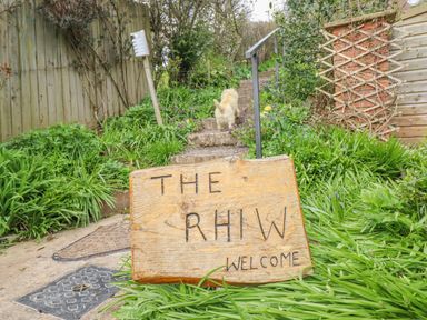 A garden with a welcome sign and steps at The Rhiw in Llanfair Caereinion
