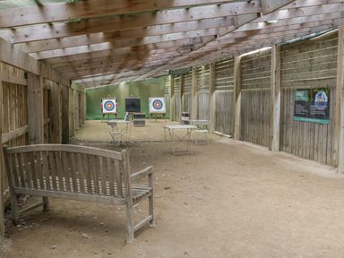 An indoor archery range with wooden beams and three archery targets at Driftwood Filey