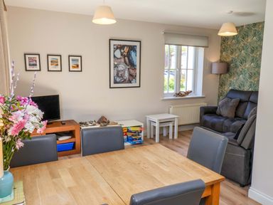 A living room with a sofa and dining table at Driftwood in Filey