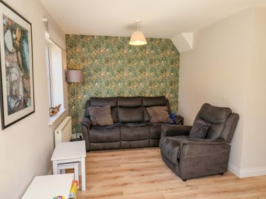 A living room with a sofa and chair at Driftwood in Filey
