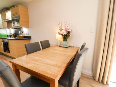 A dining room with a wooden table and chairs at Driftwood in Filey