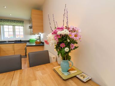 A kitchen with flowers on a dining table at Driftwood in Filey