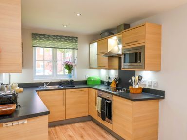 A kitchen with cabinets and appliances at Driftwood in Filey