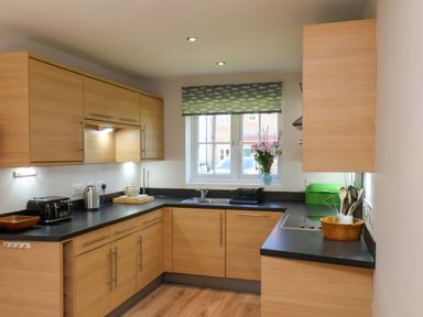 A kitchen with wooden cabinets and a sink at Driftwood in Filey