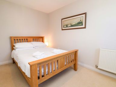 A bedroom with a wooden bed and lamp at Driftwood in Filey