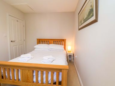 A bedroom with a bed and lamp at Driftwood in Filey
