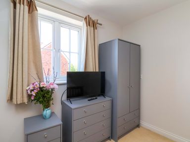 A bedroom with a television and drawers at Driftwood in Filey