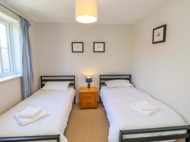 A bedroom with two single beds and a nightstand at Driftwood in Filey