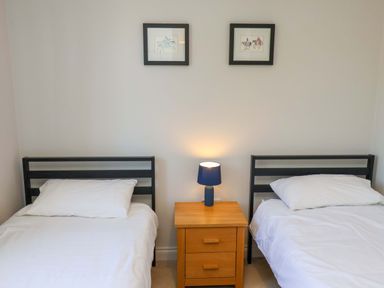 A bedroom with two beds and a nightstand at Driftwood in Filey