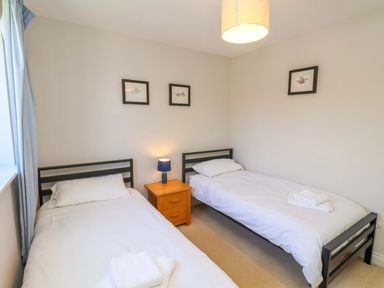 A bedroom with two beds and a lamp at Driftwood in Filey