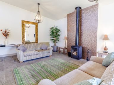 A living room with two sofas a green striped rug a fireplace and a large mirror at The Croft in Leigh Sinton