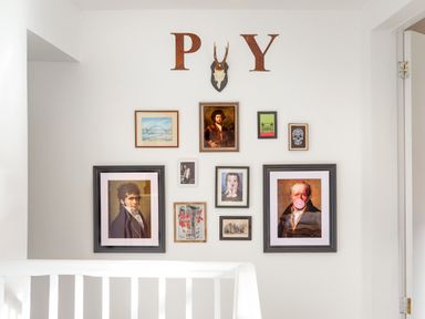 A wall with various framed pictures and a mounted antelope skull above a white railing at 1 Pringles Yard in Alnwick