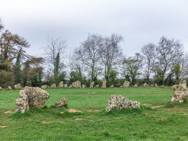 A stone circle on green grass with leafless trees in the background at Victoria Cottage in Chipping Norton