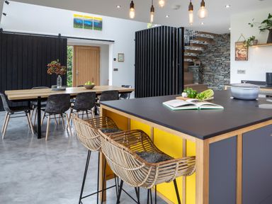 A kitchen and dining area with a wooden dining table and black chairs at Gatesgarth in Coniston