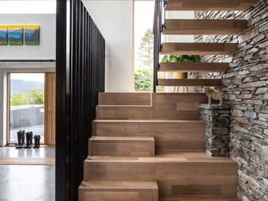 A wooden staircase with stone wall and a sculpture of an animal at Gatesgarth in Coniston