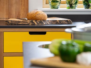 A kitchen countertop with a loaf of bread on a cutting board and green bell peppers on a counter at Gatesgarth in Coniston