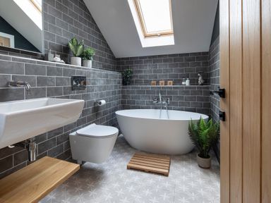 A bathroom with a bathtub a toilet a sink and plants at Gatesgarth in Coniston