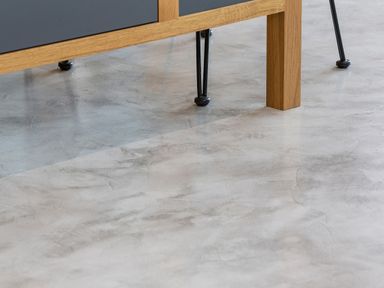 The lower legs of furniture on a polished concrete floor at Gatesgarth in Coniston