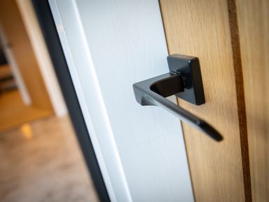 A close up of a black door handle on a wooden door at Gatesgarth in Coniston