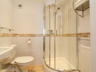 A bathroom with a toilet sink and a glass shower enclosure at Beach Lodge in Woolacombe